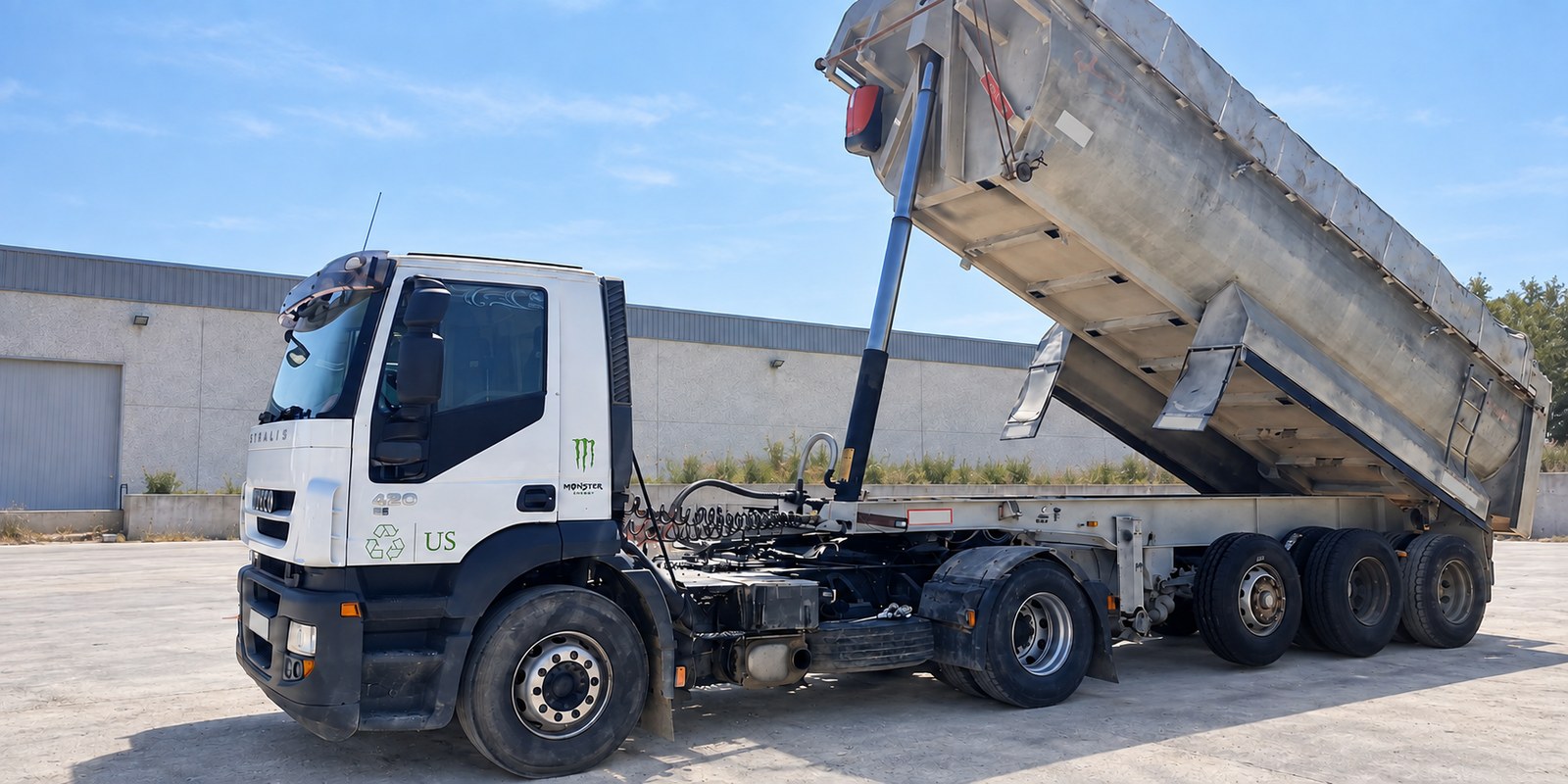 Iveco Stralis de Grup Fusió con la bañera basculante levantada, vista lateral completa